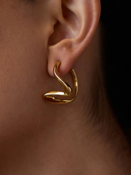 Golden Coil Studs in 18K gold, featuring a serpent-inspired design that wraps elegantly around the ear lobe.
